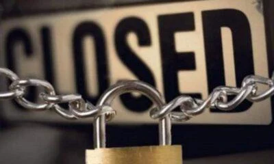 Πινακίδα «Closed» με αλυσίδα και λουκέτο σε κλειστό κατάστημα