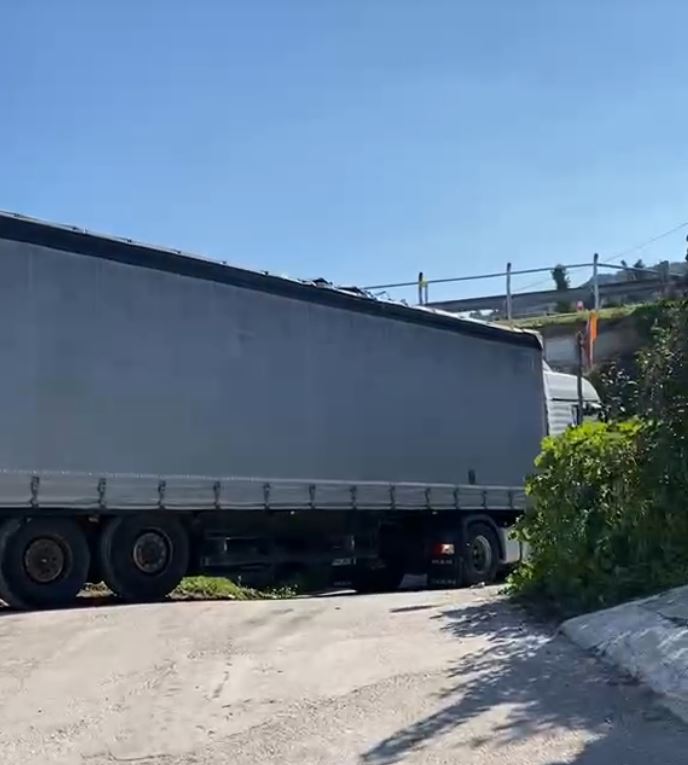 Νταλίκα, εγκλωβισμός, Τσουκαλέικα, παράδρομος, Εθνική Οδός, οδηγός, Ρουμάνος, στενός δρόμος, απεγκλωβισμός, ζημιές, σήμα STOP, μάντρα, νεκροταφείο, κάτοικοι, τοπικές αρχές, κυκλοφοριακό πρόβλημα, όχημα, ατύχημα, βοήθεια, αναστάτωση