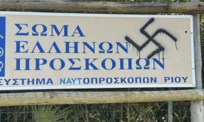 βεβήλωση, Ναυτοπρόσκοποι, Ρίο Πατρών, σβάστικες, ναζιστικά σύμβολα, Αδόλφος Χίτλερ, ρητορική μίσους, τοπική κοινωνία, αστυνομική έρευνα, Έλος Αγυιάς, καταδίκη, κοινωνική συνοχή, δημοκρατία, μνήμη θυμάτων, Β' Παγκόσμιος Πόλεμος