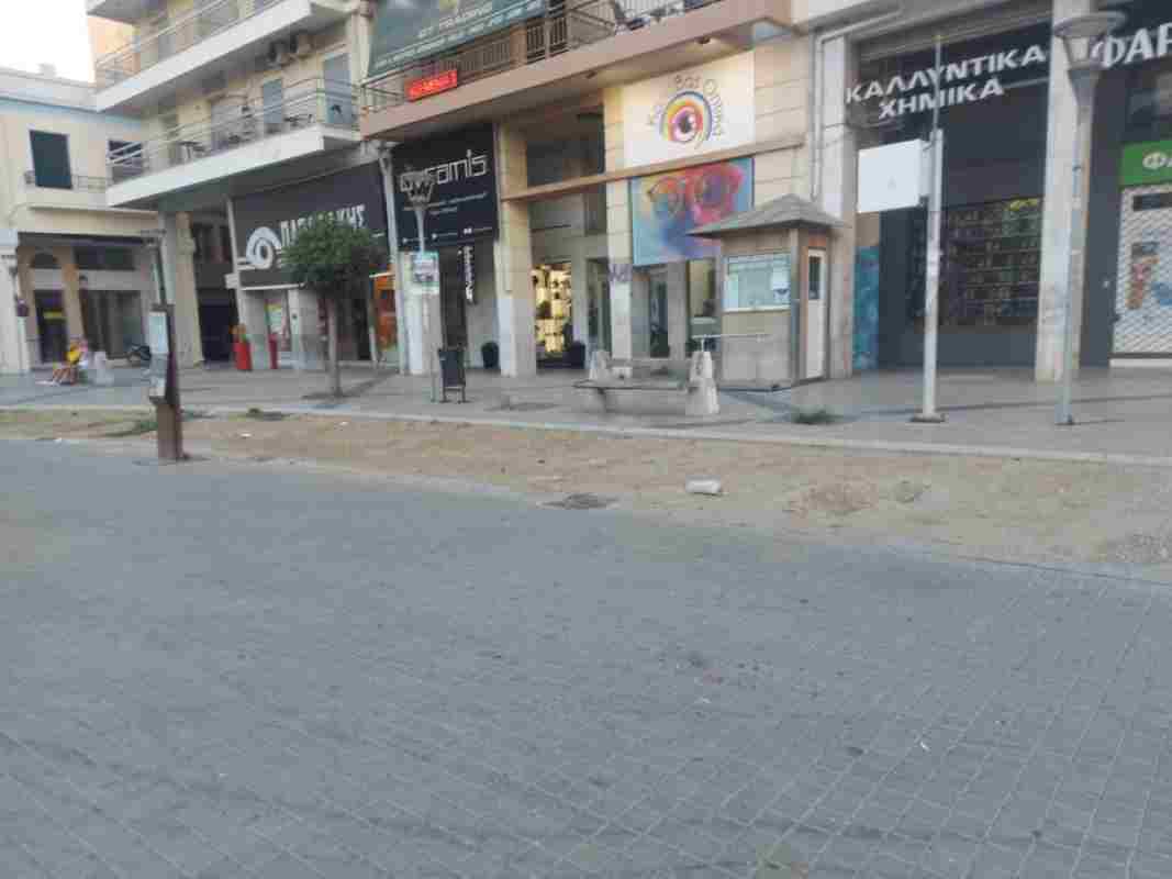 πλατεία Γεωργίου, Georgiou Square, πεζοδρόμηση Μαιζώνος, Maizonos pedestrianization, ανάπλαση Πάτρα, Patras regeneration, κεντρική πλατεία Πάτρας, Patras central square, έργα ανάπλασης, redevelopment works, καθυστέρηση έργων, project delays, εγκατάλειψη πλατείας, square neglect, παλιά παγκάκια, old benches, κατεστραμμένες κολώνες φωτισμού, damaged light poles, εικόνα πόλης, city image, κέντρο Πάτρας, Patras city center, δημοτική αρχή Πάτρας, Patras municipality, αισθητική πόλης, urban aesthetics, πολιτιστικό κέντρο Πάτρας, Patras cultural center, κοινωνικός χώρος, social space, δημόσιος χώρος, public space