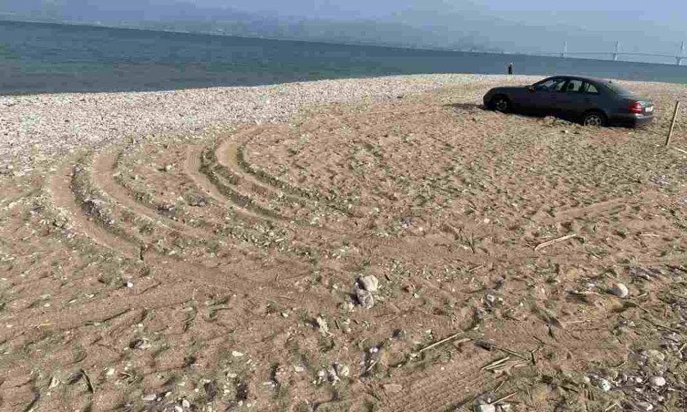 Πλαζ Πάτρας, Patras Plage, Πάτρα παραλία, Patras beach, αυτοκίνητο στην άμμο, car stuck on beach, παράνομη στάθμευση Πάτρα, illegal parking Patras, αλσύλλιο Πλαζ, Patras park, Γέφυρα Ρίου-Αντιρρίου, Rio-Antirrio Bridge, ασυδοσία, lack of civility, αστική παιδεία, civic responsibility, καταπάτηση κοινόχρηστου χώρου, public space violation, περιβαλλοντική υποβάθμιση, environmental degradation, οδηγική συμπεριφορά, driving behavior Greece, προβλήματα Πάτρας, Patras local news, Ελλάδα 2026, Greece news, viral Patras, καταγγελία πολίτη, citizen complaint, beach violation, reckless driving Patras, park safety Greece.