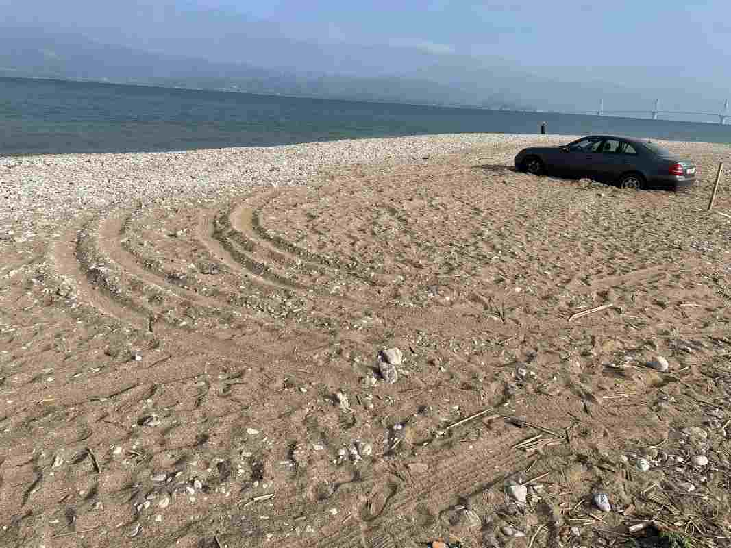 Πλαζ Πάτρας, Patras Plage, Πάτρα παραλία, Patras beach, αυτοκίνητο στην άμμο, car stuck on beach, παράνομη στάθμευση Πάτρα, illegal parking Patras, αλσύλλιο Πλαζ, Patras park, Γέφυρα Ρίου-Αντιρρίου, Rio-Antirrio Bridge, ασυδοσία, lack of civility, αστική παιδεία, civic responsibility, καταπάτηση κοινόχρηστου χώρου, public space violation, περιβαλλοντική υποβάθμιση, environmental degradation, οδηγική συμπεριφορά, driving behavior Greece, προβλήματα Πάτρας, Patras local news, Ελλάδα 2026, Greece news, viral Patras, καταγγελία πολίτη, citizen complaint, beach violation, reckless driving Patras, park safety Greece.
