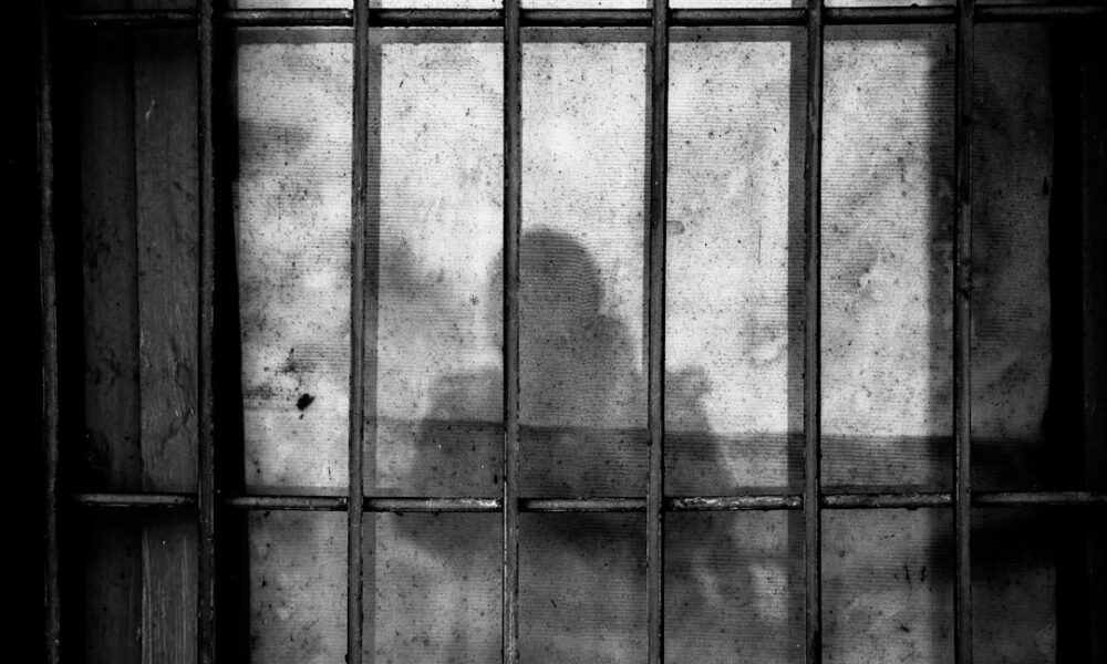 Φιγούρα πίσω από κάγκελα — συμβολική φωτογραφία, δεν απεικονίζει το CECOT
