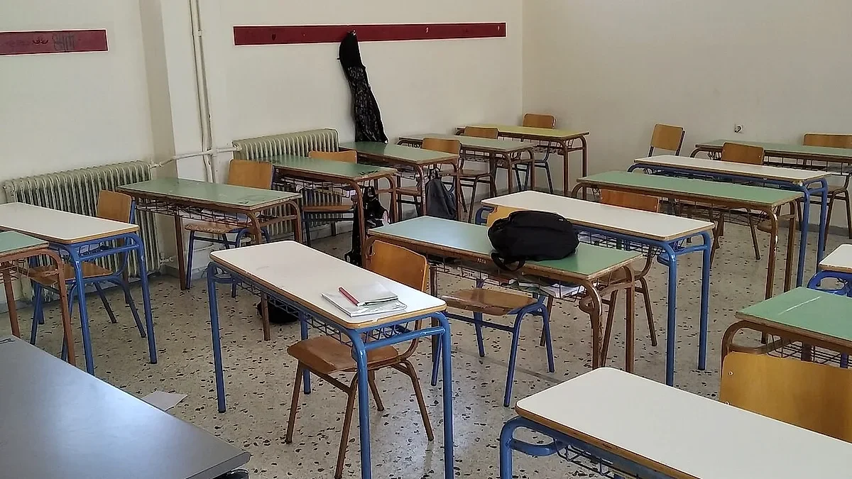 Άδεια σχολική αίθουσα με θρανία και καρέκλες