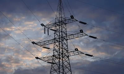 Πυλώνας υψηλής τάσης με καλώδια μεταφοράς ηλεκτρικού ρεύματος σε συννεφιασμένο ουρανό