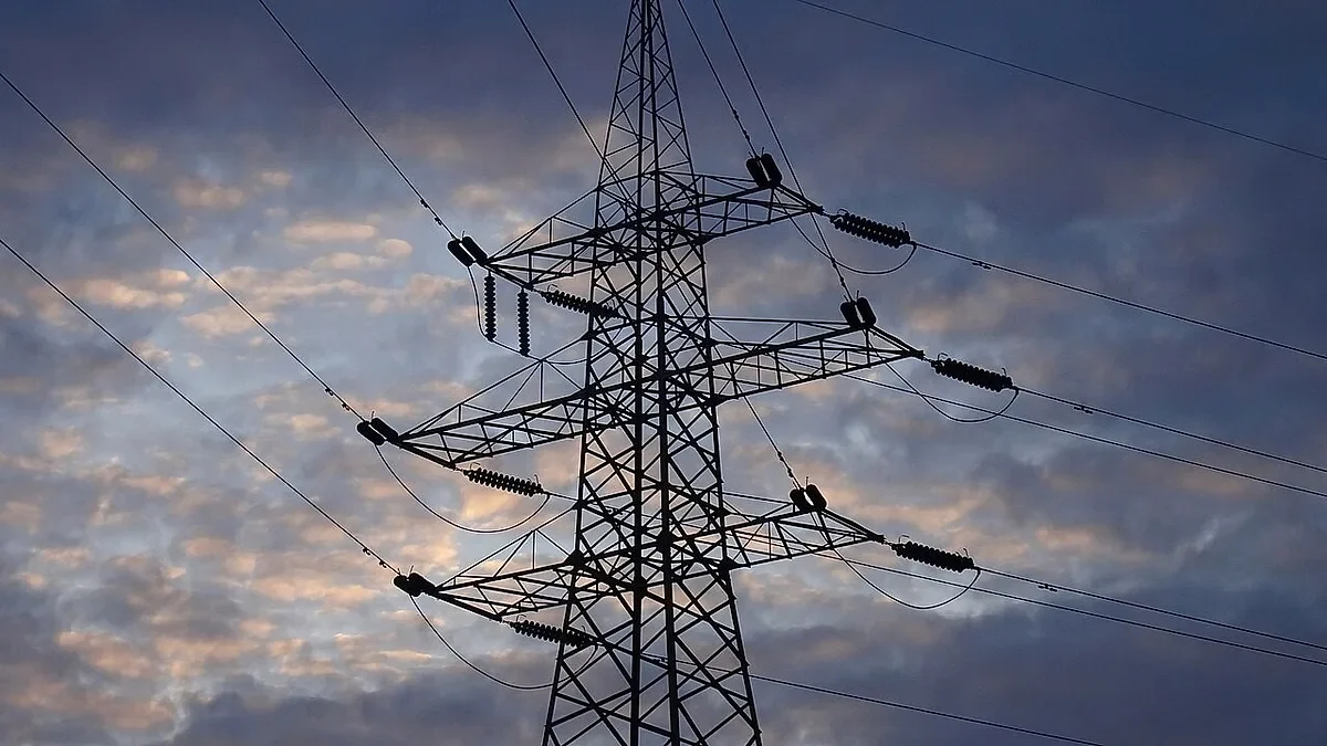 Πυλώνας υψηλής τάσης με καλώδια μεταφοράς ηλεκτρικού ρεύματος σε συννεφιασμένο ουρανό