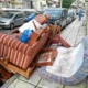 Παλιά έπιπλα και στρώματα πεταμένα σε δρόμο και πεζοδρόμιο δίπλα σε σταθμευμένα αυτοκίνητα