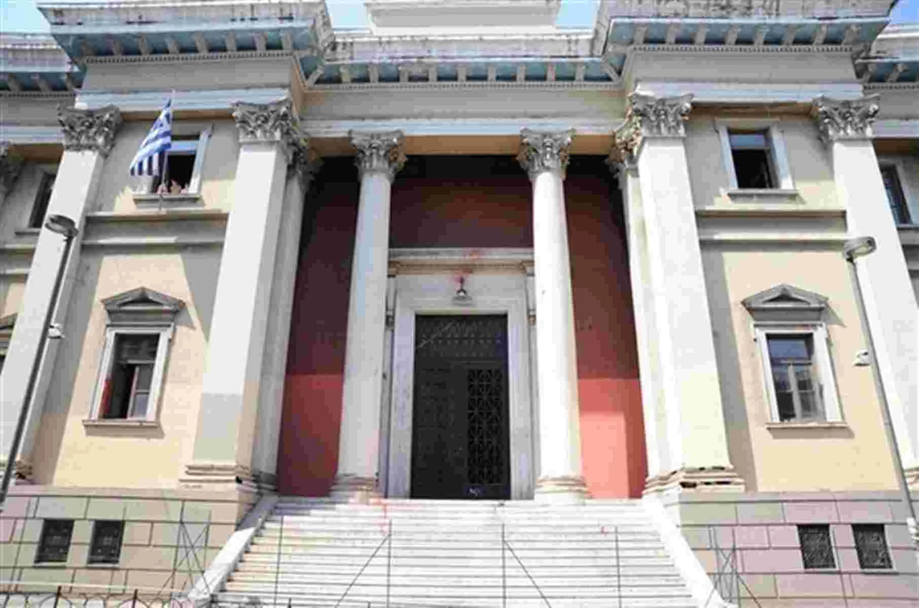 Η πρόσοψη κτιρίου με κολόνες, σκάλες και ελληνική σημαία
