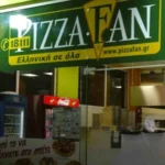 Η πρόσοψη καταστήματος εστίασης με πράσινη επιγραφή και διαφημιστικά στοιχεία.