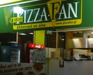 Η πρόσοψη καταστήματος εστίασης με πράσινη επιγραφή και διαφημιστικά στοιχεία.