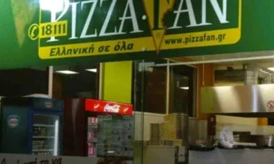 Η πρόσοψη καταστήματος εστίασης με πράσινη επιγραφή και διαφημιστικά στοιχεία.