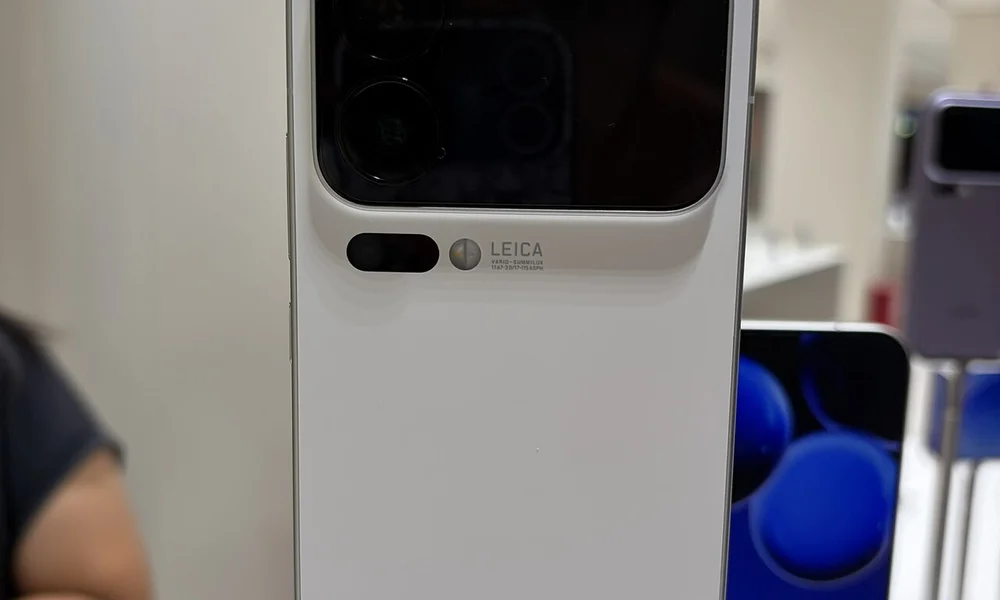 Πίσω όψη λευκού smartphone σε βάθρο έκθεσης, με διπλή οθόνη και κάμερες