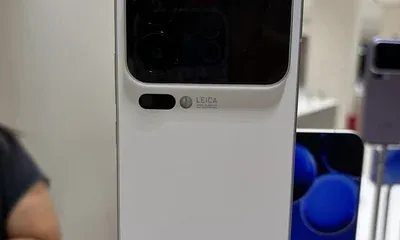 Πίσω όψη λευκού smartphone σε βάθρο έκθεσης, με διπλή οθόνη και κάμερες