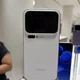 Πίσω όψη λευκού smartphone σε βάθρο έκθεσης, με διπλή οθόνη και κάμερες