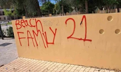 Τοίχος με κόκκινα γκράφιτι σε εξωτερικό χώρο με πλακόστρωτο.
