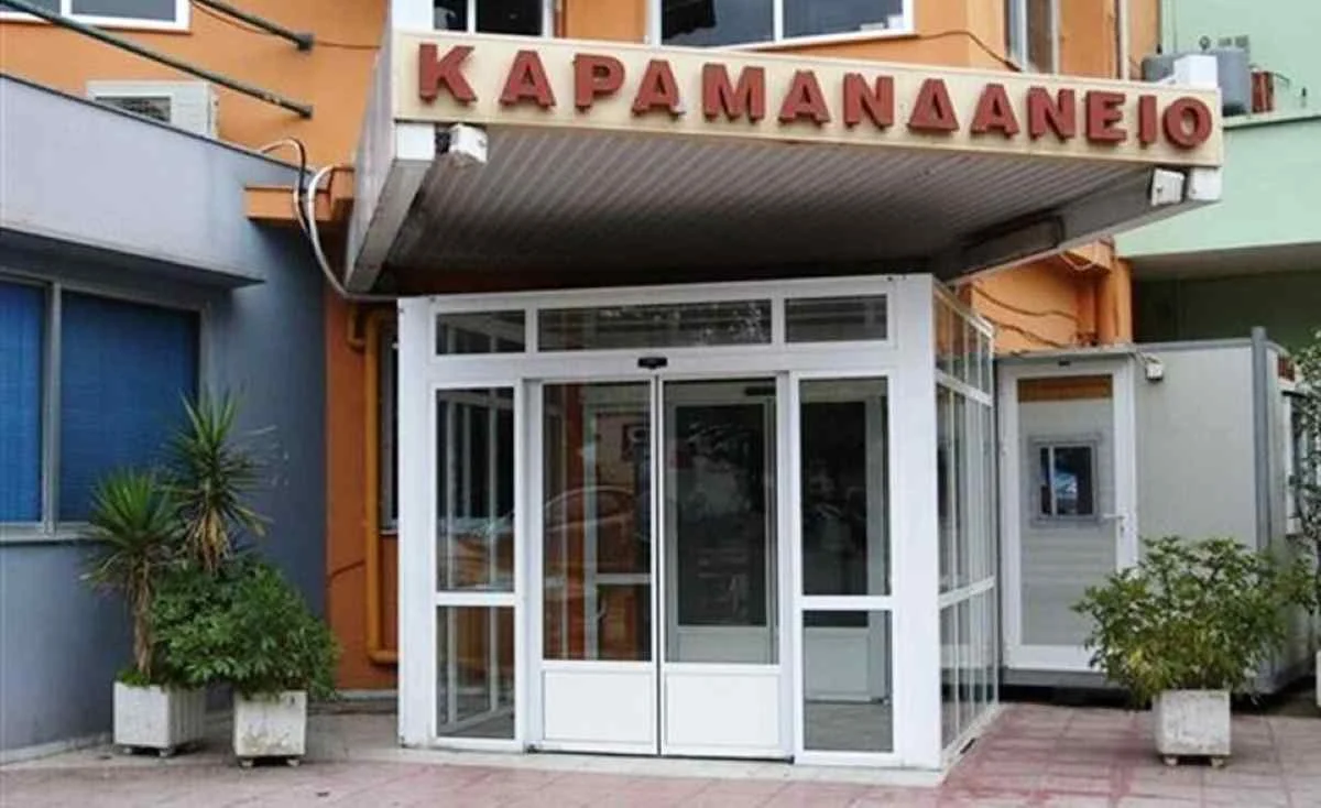 Η είσοδος κτιρίου με γF τζάμια και επιγραφή στα ελληνικά πάνω από τη θύρα.
