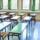 Άδεια σχολική αίθουσα με θρανία, καρέκλες και παράθυρα.