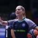 Γυναίκα διαιτητής με αθλητική εμφάνιση κρατά μπάλα μπάσκετ σε κλειστό γήπεδο