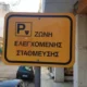 Κίτρινη πινακίδα ζώνης ελεγχόμενης στάθμευσης σε δρόμο πόλης.