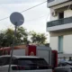 Πυροσβεστικό όχημα έξω από πολυκατοικία με αυτοκίνητα και πινακίδα στον δρόμο