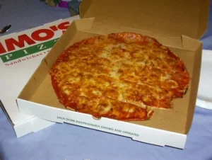 Πίτσα μέσα σε ανοιχτό χάρτινο κουτί delivery πάνω σε τραπέζι