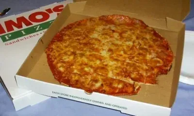 Πίτσα μέσα σε ανοιχτό χάρτινο κουτί delivery πάνω σε τραπέζι