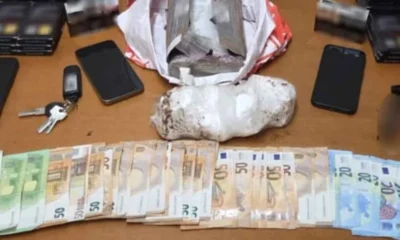 Πάνω σε τραπέζι ακουμπούν χαρτονομίσματα, κινητά τηλέφωνα, κλειδιά και δέματα με πιθανές παράνομες ουσίες.