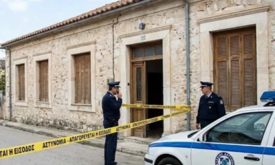 Αστυνομικοί έξω από πέτρινο κτήριο με κορδέλα αποκλεισμού και περιπολικό