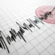 Σεισμογράφημα σε χαρτί με γραμμές καταγραφής και κόκκινους ομόκεντρους κύκλους