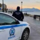 Περιπολικό της αστυνομίας σταθμευμένο σε παραλιακό πεζόδρομο την ώρα του ηλιοβασιλέματος, με αστυνομικό σε κοντινή απόσταση.