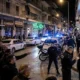 Νυχτερινή άποψη δρόμου με αστυνομικά οχήματα, μοτοσικλέτες και συγκεντρωμένο πλήθος