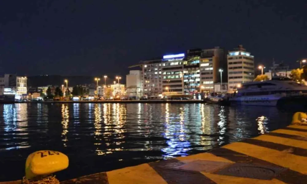 Νυχτερινή άποψη λιμανιού με φώτα πόλης και πλοία