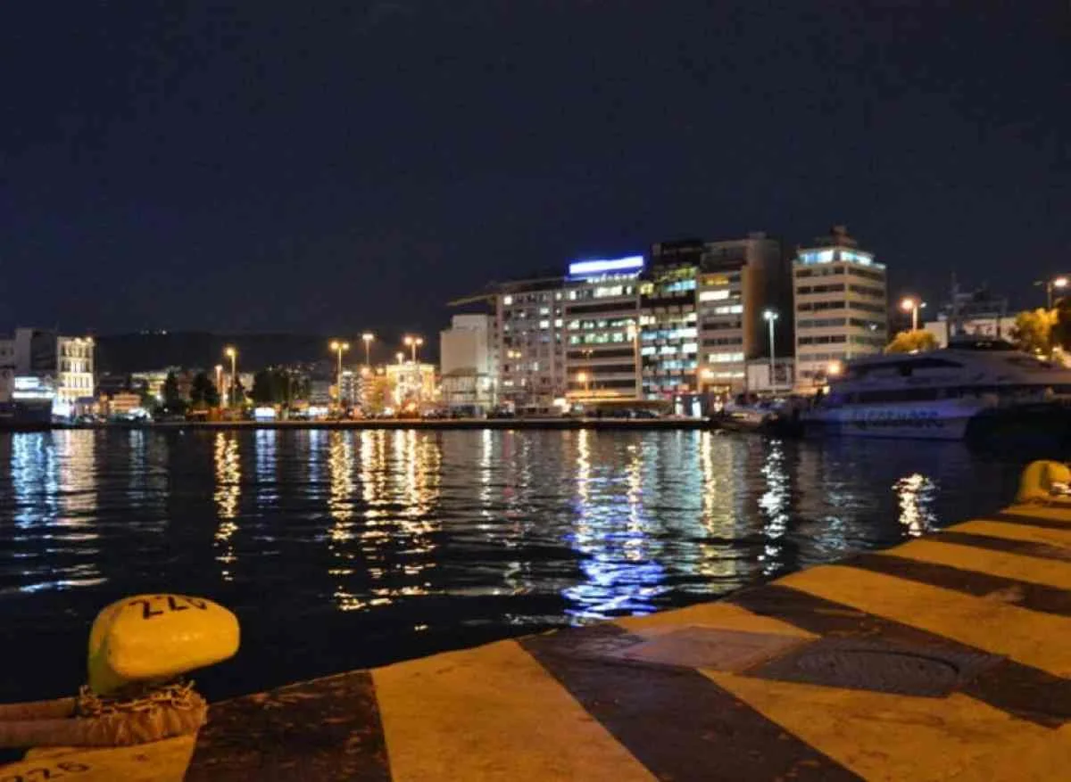 Νυχτερινή άποψη λιμανιού με φώτα πόλης και πλοία