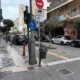 Αυτοκίνητα σταθμευμένα σε αστικό πεζόδρομο δίπλα σε πινακίδες κυκλοφορίας και κτίρια.