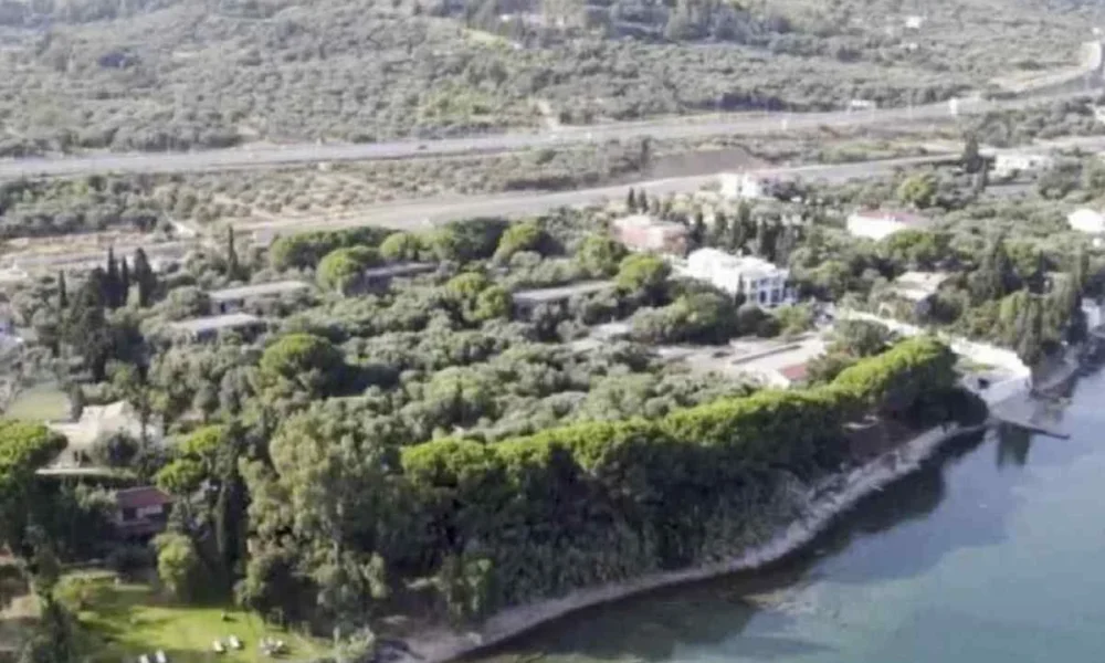 Αεροφωτογραφία παράκτιας έκτασης με δέντρα, κτίσματα και δρόμο στο βάθος