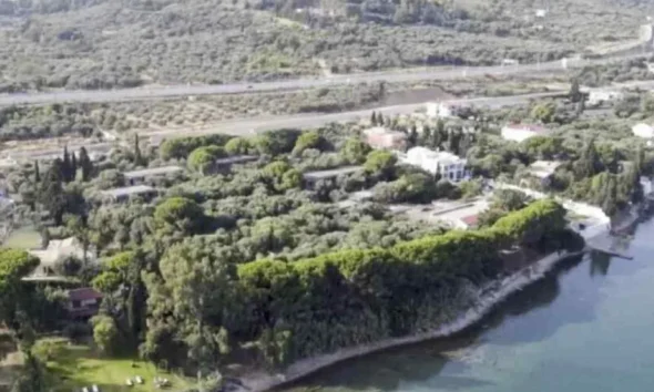 Αεροφωτογραφία παράκτιας έκτασης με δέντρα, κτίσματα και δρόμο στο βάθος