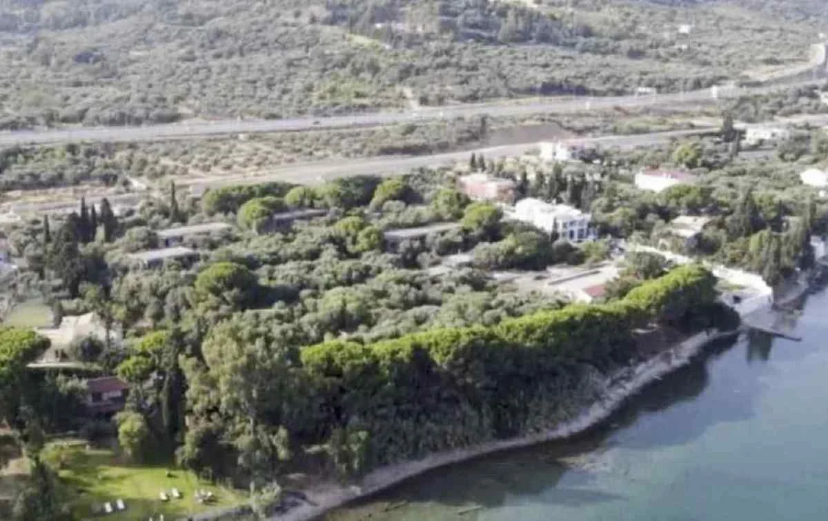 Αεροφωτογραφία παράκτιας έκτασης με δέντρα, κτίσματα και δρόμο στο βάθος