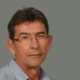 Πορτραίτο άντρα με γυαλιά οράσεως και ριγέ πουκάμισο σε ουδέτερο φόντο