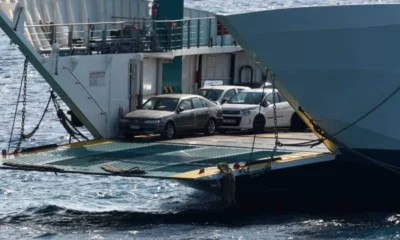 Αυτοκίνητα σταθμευμένα στο γκαράζ πλοίου με ανοιχτό καταπέλτη πάνω στη θάλασσα