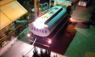 Βυτιοφόρο όχημα σταθμευμένο σε δρόμο νυχτερινή ώρα με ανοιχτά φώτα και λάστιχο στο έδαφος