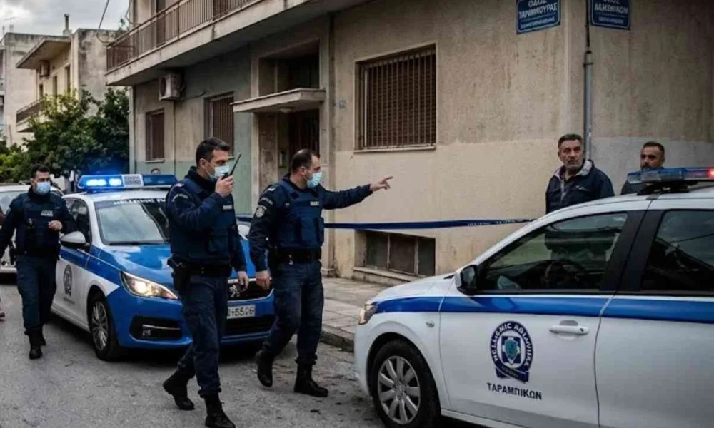 Αστυνομικές δυνάμεις και περιπολικά έξω από πολυκατοικία σε δρόμο.