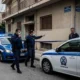 Αστυνομικές δυνάμεις και περιπολικά έξω από πολυκατοικία σε δρόμο.