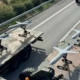 Τέσσερα μη επανδρωμένα αεροσκάφη τοποθετημένα σε πλατφόρμες πάνω σε φορτηγά οχήματα σε δρόμο