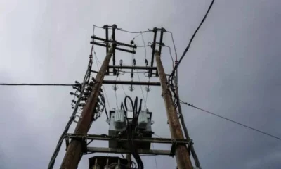 Ξύλινες κολώνες μεταφοράς ηλεκτρικού ρεύματος με καλώδια και μετασχηματιστή σε εξωτερικό χώρο.