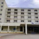 Εξωτερική άποψη πολυώροφου κτιρίου νοσοκομείου με είσοδο και παράθυρα.