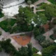 Πανοραμική άποψη πάρκου με δέντρα, διαδρόμους περιπάτου και παιδική χαρά από ψηλά.