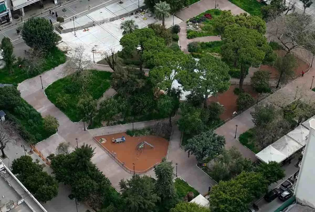 Πανοραμική άποψη πάρκου με δέντρα, διαδρόμους περιπάτου και παιδική χαρά από ψηλά.