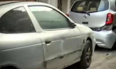 Δύο ασημί αυτοκίνητα σταθμευμένα σε δρόμο, με ορατές φθορές στο αμάξωμα.