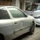 Δύο ασημί αυτοκίνητα σταθμευμένα σε δρόμο, με ορατές φθορές στο αμάξωμα.