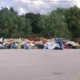 Σωρός από ογκώδη αντικείμενα, έπιπλα και απορρίμματα σε άσφαλτο μπροστά από δέντρα